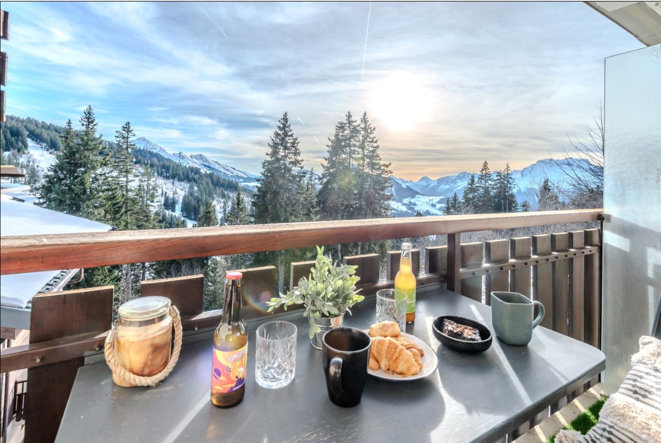 View from the balcony over the Aravis mountains, breakfast set on the outdoor table
