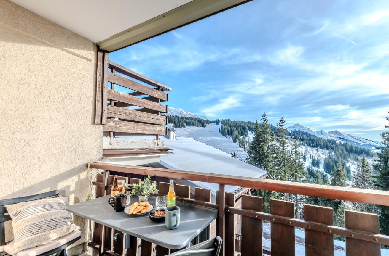 Wooden balcony with table and view over the ski slopes and forest
